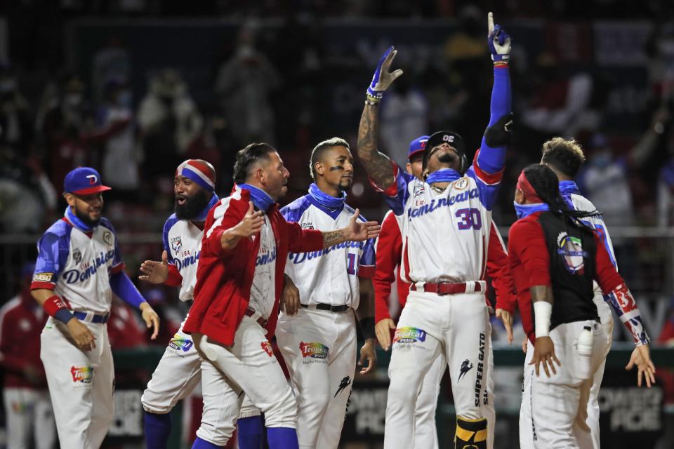 El jugador dominicano Johan Camargo alza los brazos para celebrar su jonrón solitario, en el quinto inning de su juego contra Puerto Rico, en la final de la Serie del Caribe en el estadio Teodoro Mariscal de Mazatlán, México, el sábado 6 de febrero de 2021. (AP Foto/Moisés Castillo)