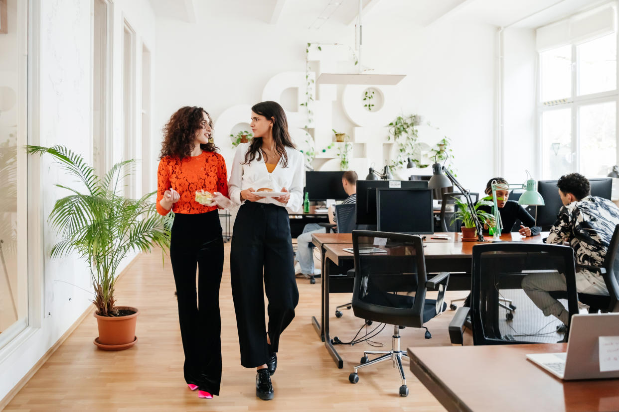 Two female friends at work. (Getty Images)