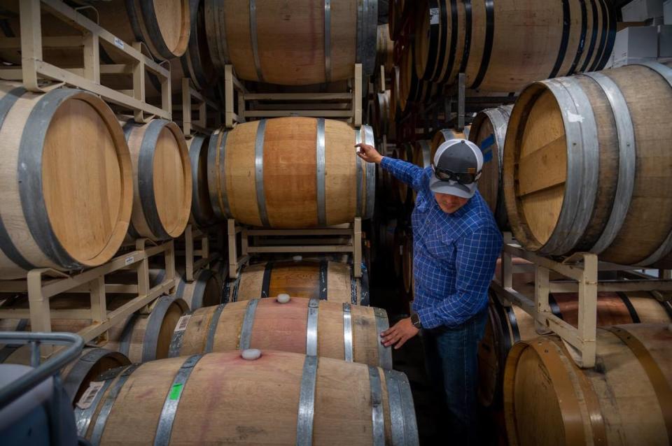 Gerardo Espinosa mira barriles de vino donde hace vino para una variedad de bodegas en Lodi Crush, el martes 19 de octubre de 2021, en Lodi.