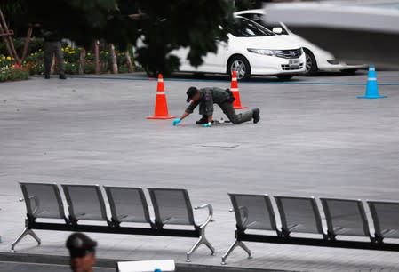 A Police Explosive Ordnance Disposal (EOD) officer works following a small explosion at a site in Bangkok