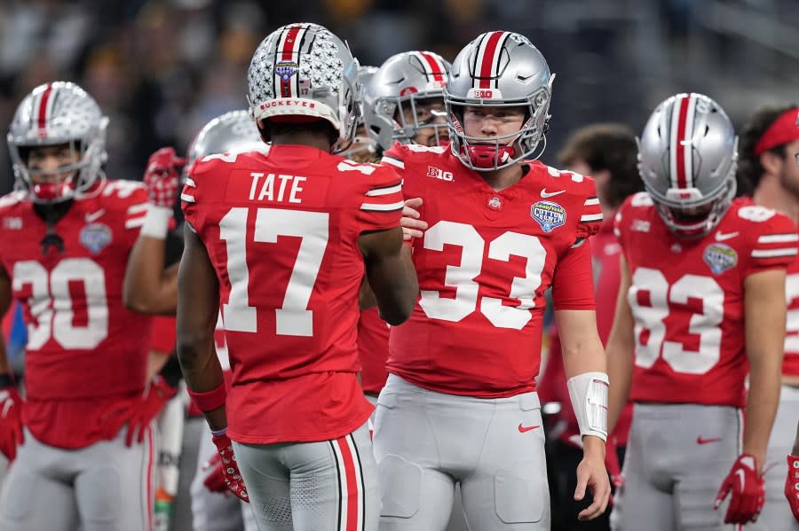 ARLINGTON, TEXAS – DECEMBER 29: Devin Brown #33 of the Ohio State Buckeyes shakes hands with Carnell Tate #17 prior to a game against the Missouri Tigers during the Goodyear Cotton Bowl at AT&T Stadium on December 29, 2023 in Arlington, Texas. (Photo by Sam Hodde/Getty Images)