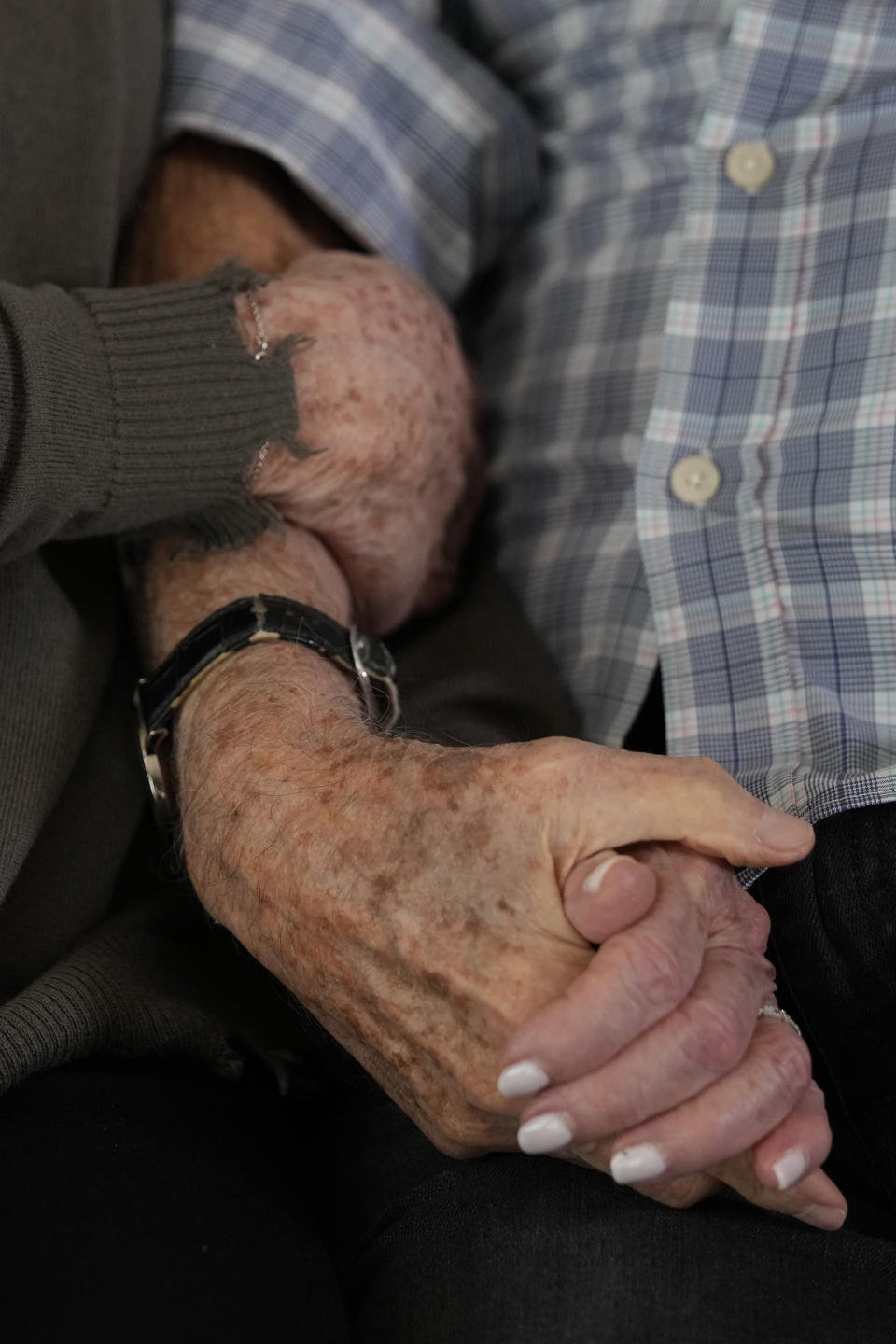 World War II veteran Harold Terens, 100, right, holds hands with Jeanne Swerlin, 96, as they speak during an interview, Thursday, Feb. 29, 2024, in Boca Raton, Fla. Terens will be honored by France as part of the country's 80th anniversary celebration of D-Day. In addition, the couple will be married on June 8 at a chapel near the beaches where U.S. forces landed. (AP Photo/Wilfredo Lee)