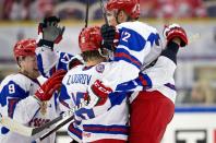 Russia's Anton Slepyshev, left joins happy team mates Nikita Zadorov, center, and Ivan Barbashyov after Slepyshev scored 3-4 in the World Junior Hockey Championships quarter final between USA and Russia in Malmo, Sweden on Thursday, Jan. 2, 2014. (AP Photo / TT News Agency / Andreas Hillergren) ** SWEDEN OUT **