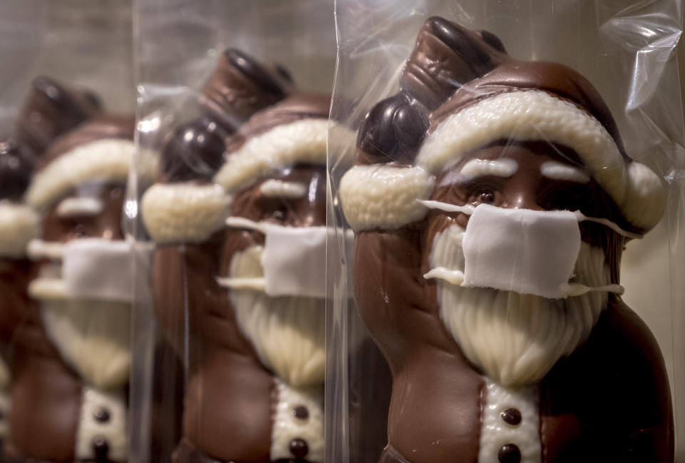 A confectioner offers chocolate Santa Claus wearing a face mask, displayed in the window of a shop in central Frankfurt, Germany, Sunday, Nov. 22, 2020. (AP Photo/Michael Probst)