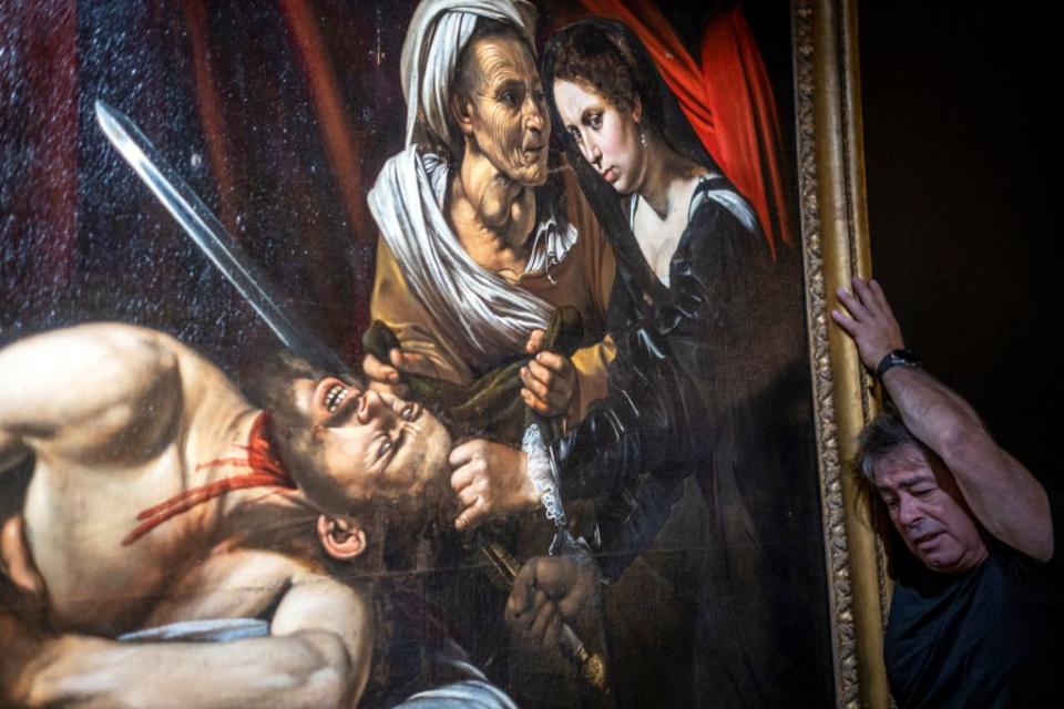 A technician works on the hanging of a painting believed by some experts to be Caravaggio's "Judith Beheading Holofernes" for its public presentation at the Marc Labarbe auction house on June 16, 2019 in Toulouse before it goes under the hammer next June 27, five years after it was discovered in the attic of an old house in Toulouse. Source: Getty