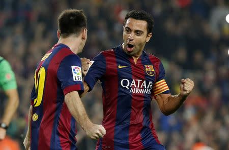 Barcelona's Lionel Messi (L) celebrates his goal against Sevilla with teammate captain Xavi Hernandez during their Spanish first division soccer match at Nou Camp stadium in Barcelona November 22, 2014. REUTERS/Gustau Nacarino