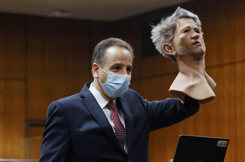 Deputy District Attorney Habib A. Balian holds a rubber latex mask, worn by Robert Durst when police arrested him, Wednesday, Sept. 8, 2021 in Inglewood, Calif. Robert Durst is a champion at running from responsibility, covering his tracks with lies so numerous he couldn't keep them all straight, a prosecutor said Wednesday during closing arguments in the New York real estate heir's murder trial. (Al Seib/Los Angeles Times via AP, Pool)