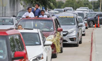 Children use a speaker to pray while waiting with others during a drive-through Eid al-Fitr celebration outside a closed mosque in Plano, Texas, Sunday, May 24, 2020, during the coronavirus pandemic. (AP Photo/LM Otero)