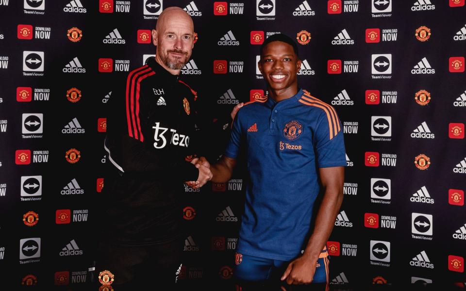 Tyrell Malacia poses with Erik ten Hag after signing his contract with the club - GETTY IMAGES