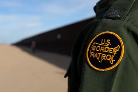 A U.S. border patrol agent walks along the border fence between Mexico and the United States near Calexico, California, U.S. February 8, 2017. REUTERS/Mike Blake