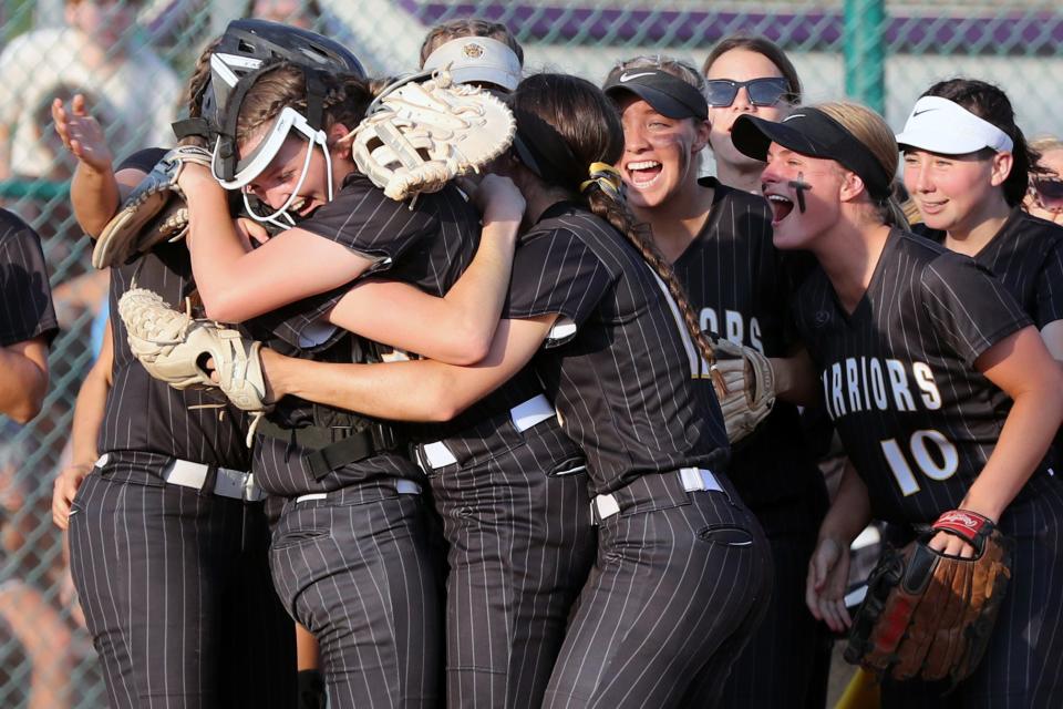 Watkins Memorial's Carsyn Cassady, left, is swarmed by teammates as they celebrate a 9-1 victory over Westerville Central in a Division I district final game May 20 at Pickerington High School Central.