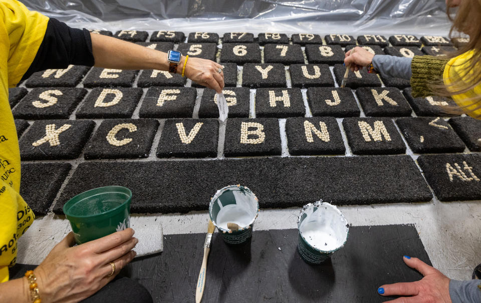 Volunteers decorate Coding for Veterans Rose Parade float titled "Sounds of Success"