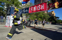 <p>Robert Sutherland, of Farmingdale, N.Y., a member of the East Farmingdale Fire Department, crosses the finish line during the Stephen Siller Tunnel to Towers memorial event in New York, Sept. 25 2016. The run honors New York firefighter Stephen Siller who made his way from his Brooklyn firehouse through the Hugh Carey Tunnel, then known as the Brooklyn Battery Tunnel, to the World Trade Center, where he died in the collapse of the towers on Sept. 11, 2001. (Photo: Craig Ruttle/AP)</p>