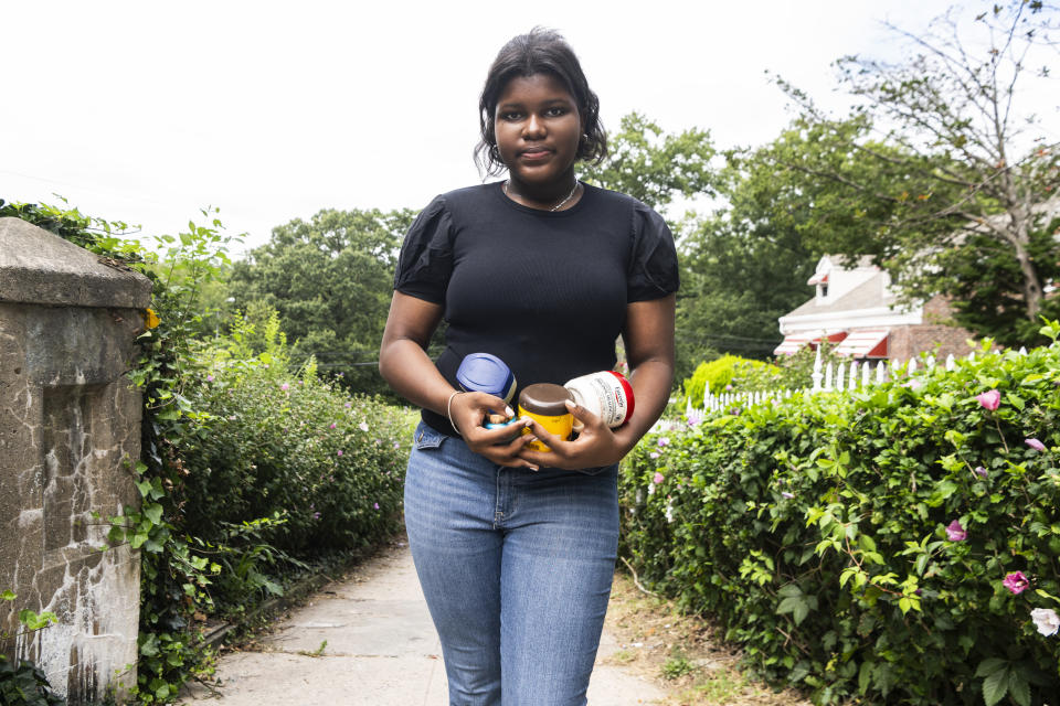 Mia Hall, 14, poses for a portrait in her neighborhood park while holding some skin care products she uses regularly on Thursday, Aug. 29, 2024, in the Bronx borough of New York. (AP Photo/Brittainy Newman)