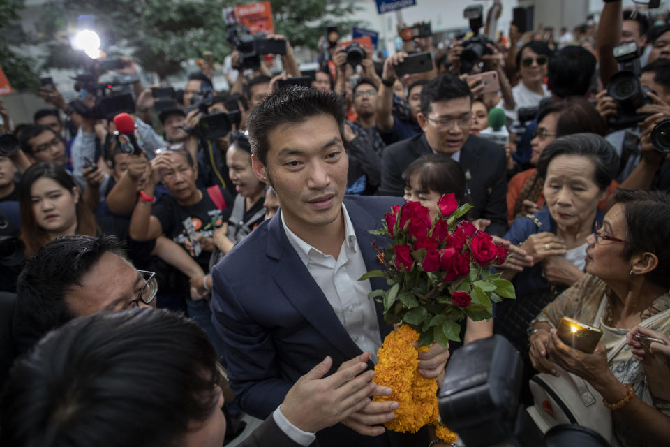 Thanathorn Juangroongruangkit, center, leader of the anti-military Future Forward Party is surrounded by his supporters as he arrives at Constitutional Court in Bangkok, Thailand, Wednesday, Nov. 20, 2019. Thanathorn is expected to receive a verdict whether he is eligible to remain as a member of the parliament due to an accusation of owning media shares a violation of the Thai constitution. (AP Photo/Gemunu Amarasinghe)