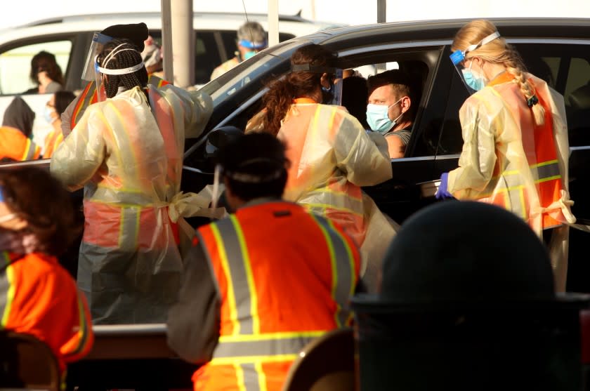 NORTHRIDGE, CA - JANUARY 14, 2021 - A man waits for a vaccine against COVID-19 as medical staff and workers tend to a large scale COVID-19 vaccine site at California State University Northridge in Northridge on January 19, 2021. Los Angeles County opened four other large-scale vaccine sites Tuesday -- at Six Flags Magic Mountain, the Pomona Fairplex, the L.A. County Office of Education in Downey and The Forum in Inglewood. The sites will eventually have the capability to vaccinate 4,000 people each on a daily basis -- depending on vaccine availability. Los Angeles County began scheduling COVID-19vaccination appointments for residents aged 65 and older today, advancing an effort that wasn't expected to start until February, but limited vaccine supplies and uncertainty about future allocations has left the inoculation effort shrouded in doubt. County Public Health Director Barbara Ferrer said there are adequate vaccine supplies to get through this week's appointments -- about 50,000 of them at the public sites -- but the county has no idea how many more doses it'll be getting next week. (Genaro Molina / Los Angeles Times)