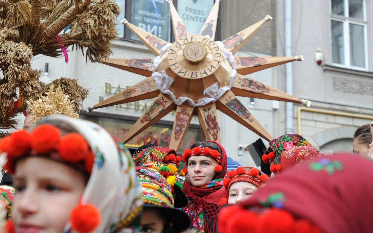 Ukrainians sing Christmas carols as they carry decorated stars of Bethlehem in Lviv - REX