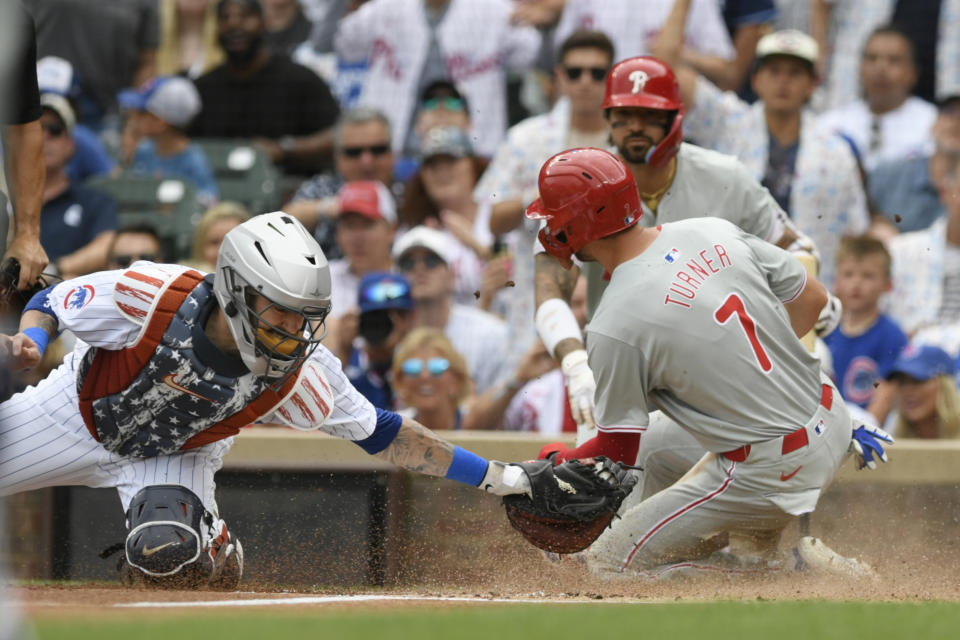 Philadelphia Phillies' Trea Turner (7) slides into home plate safely on a Brandon Marsh single while Chicago Cubs catcher Tomas Nido left, tries to apply the tag during the first inning of a baseball game Thursday, July 4, 2024, in Chicago. (AP Photo/Paul Beaty)