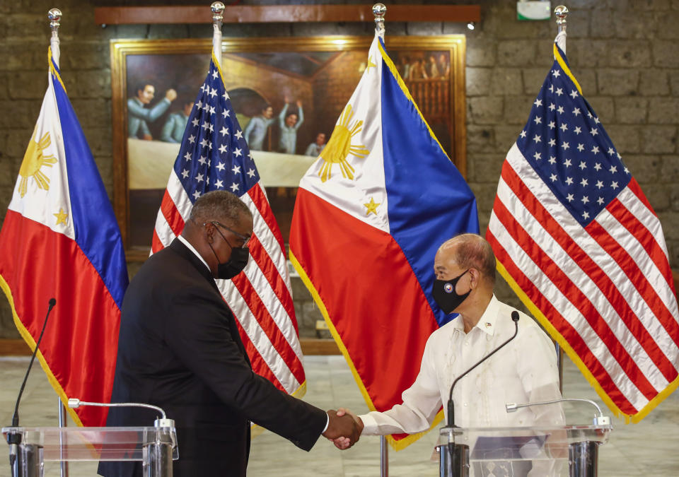 United States Defense Secretary Lloyd Austin, left, and Philippines Defense Secretary Delfin Lorenzana shake hands after a bilateral meeting at Camp Aguinaldo military camp in Quezon City, Metro Manila, Philippines Friday, July 30, 2021. Austin is visiting Manila to hold talks with Philippine officials to boost defense ties and possibly discuss the The Visiting Forces Agreement between the US and Philippines. (Rolex dela Pena/Pool Photo via AP)