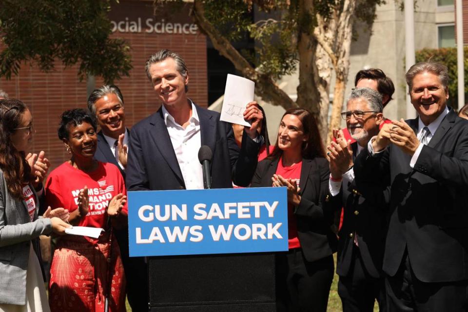 Members of gun safety group Moms Demand Action celebrate as Gov. Gavin Newsom signs firearm legislation modeled after Texas abortion ban. The organization has lobbied for an Assembly bill that would levy a state excise tax on gun and ammunition dealers, vendors and manufacturers.