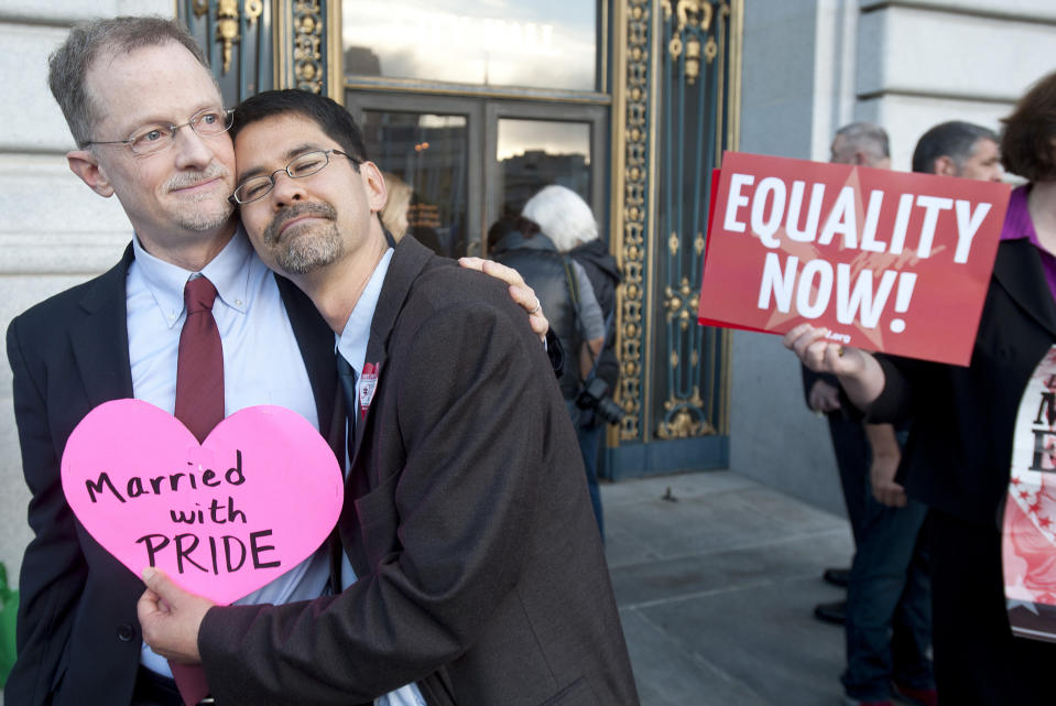 FILE - John Lewis, left, and Stuart Gaffney embrace outside San Francisco's City Hall shortly before the U.S. Supreme Court ruling cleared the way for same-sex marriage in California on Wednesday, June 26, 2013. The justices issued two 5-4 rulings in their final session of the term. One decision wiped away part of a federal anti-gay marriage law that has kept legally married same-sex couples from receiving tax, health and pension benefits. The other was a technical legal ruling that said nothing at all about same-sex marriage, but left in place a trial court's declaration that California's Proposition 8 is unconstitutional. (AP Photo/Noah Berger, File)