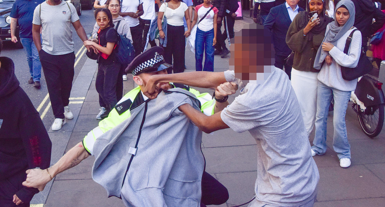 A police officer appears to be punched by a man during the disorder on Oxford Street on Wednesday. (Shutterstock)