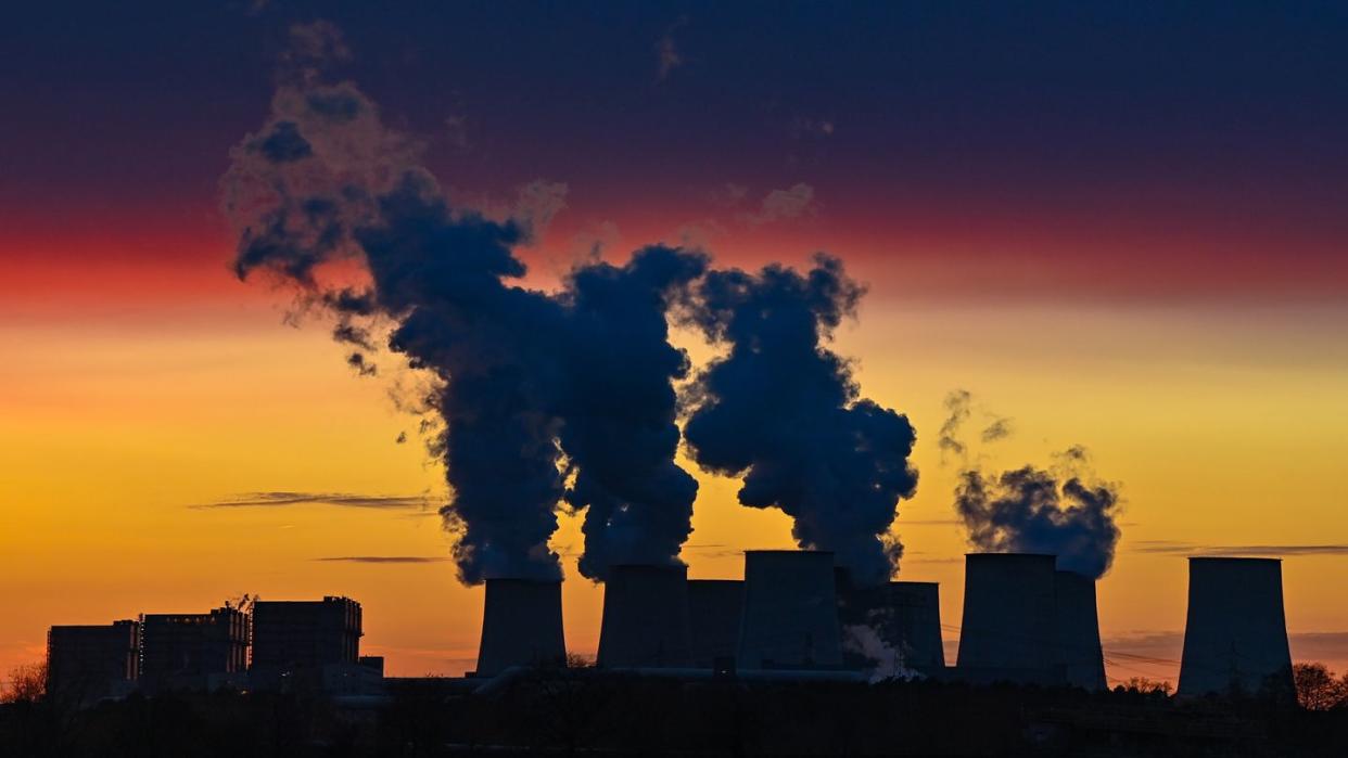 Farbenprächtig leuchten die Wolken im Sonnenuntergang über den Kühltürmen des Braunkohlekraftwerks Jänschwalde der Lausitz Energie Bergbau AG.