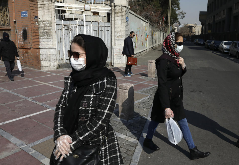 Pedestrians walk as some of them wear masks in downtown Tehran, Iran, Thursday, Feb. 27, 2020. Amid fear and uncertainty caused by the spread of a new virus, Iranians are taking extra caution to avoid getting infected, as authorities canceled Friday prayers in Tehran, Qom and other cities. (AP Photo/Vahid Salemi)