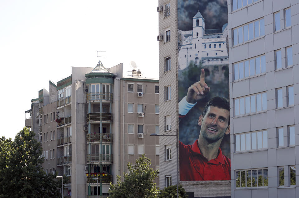 A billboard depicting Serbian tennis player Novak Djokovic and the Christian Orthodox monastery of Ostrog is seen on a building in Belgrade, Serbia, Wednesday, June 24, 2020. Djokovic has tested positive for the coronavirus after taking part in a tennis exhibition series he organized in Serbia and Croatia. The top-ranked Serb is the fourth player to test positive for the virus after first playing in Belgrade and then again last weekend in Zadar, Croatia.(AP Photo/Darko Vojinovic)