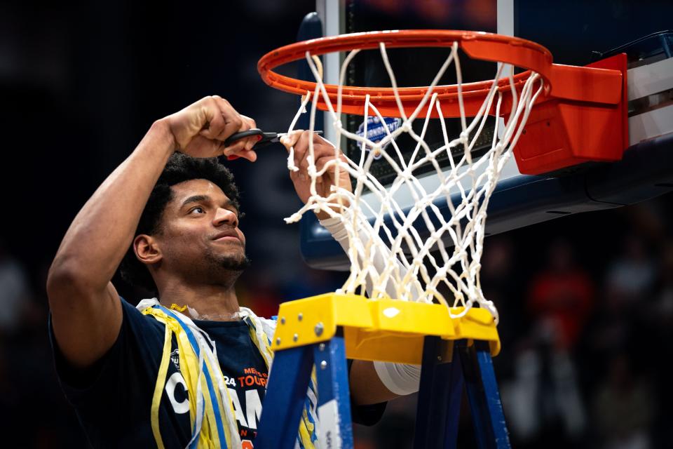 Auburn center Dylan Cardwell cuts a piece of the net after defeating Florida in the SEC tournament championship game at Bridgestone Arena in Nashville, Tenn., Sunday.