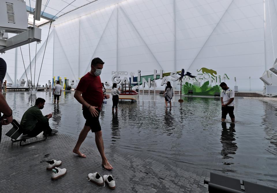 People enjoy walking inside a pool of the Brazil Pavilion at the Dubai Expo 2020, in Dubai, United Arab Emirates, Sunday, Oct, 3, 2021. (AP Photo/Kamran Jebreili)