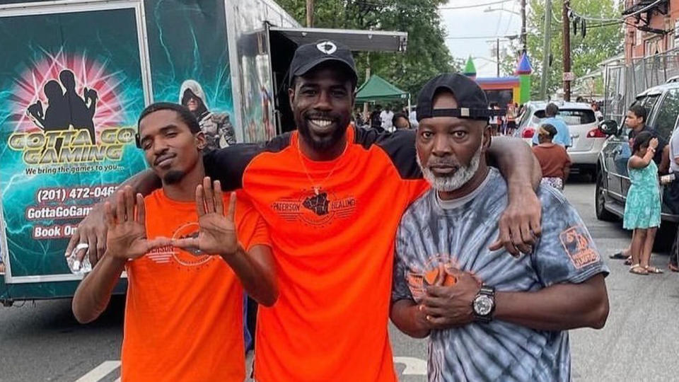 Najee Seabrooks (center) and his best friend Terrance Drakeford (left) and another man at a street festival representing the Paterson Healing Collective, a group dedicated to providing support and intervention for survivors of violence, where Seabrooks and Drakeford worked. (Paterson Healing Collective)