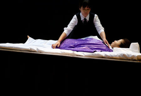 A funeral undertaker dresses a model during an encoffinment competition at Life Ending Industry EXPO 2017 in Tokyo, Japan August 24, 2017 REUTERS/Kim Kyung-Hoon