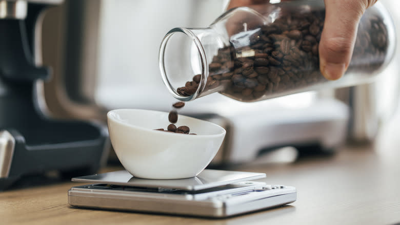 pouring coffee beans from glass bottle