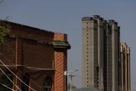 Apartment towers rise behind the former Xinqu Mosque that had its minarets removed in Changji outside Urumqi