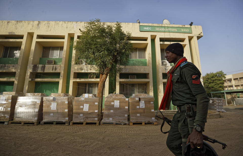 FILE- A Nigerian policeman provides security at the offices of the Independent National Electoral Commission in Kano, northern Nigeria Thursday, Feb. 14, 2019. A surge of violence targeting Nigeria's election commission offices and extremist attacks in remote communities are already raising concerns about the upcoming February elections in Africa's most populous nation. (AP Photo/Ben Curtis, File)