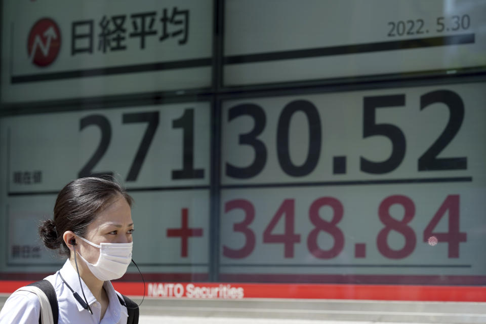 A woman wearing a protective mask walks in front of an electronic stock board showing Japan's Nikkei 225 index at a securities firm Monday, May 30, 2022, in Tokyo. Asian stocks rose Monday after Wall Street rebounded from a seven-week string of declines and China eased anti-virus curbs on business activity in Shanghai and Beijing. (AP Photo/Eugene Hoshiko)