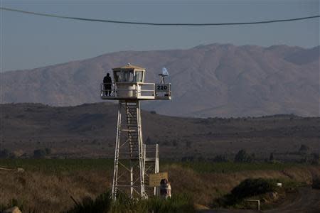 A United Nations (U.N.) peacekeeping soldier stands on an observation tower near the Quneitra border crossing between Israel and Syria, in the Israeli-occupied Golan Heights August 31, 2013. REUTERS/Ronen Zvulun