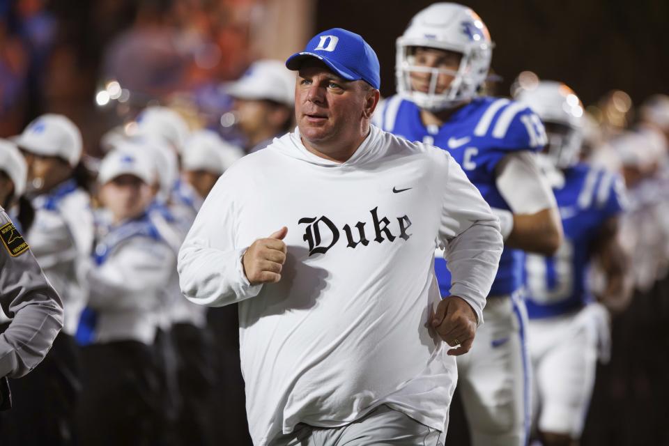 CORRECTS TO MONDAY, SEPT. 4, 2023, NOT TUESDAY, SEPT. 5, 2023 - Duke head coach Mike Elko runs onto the field before an NCAA college football game against Clemson in Durham, N.C., Monday, Sept. 4, 2023. (AP Photo/Ben McKeown)