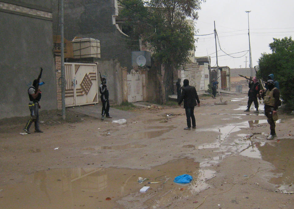 In this Saturday, Jan. 11, 2014 photo, gunmen stand guard in Fallujah, 65 kilometers (40 miles) west of Baghdad, Iraq. Fighting between security forces and al-Qaida-linked militants in Iraq's Sunni-dominated Anbar province has killed at least 60 people over the past two weeks, an official said Saturday. International observers have warned of shortages of food, fuel and other necessities, particularly in Fallujah. United Nations records show that more than 11,000 families have been uprooted by the fighting. (AP Photo)