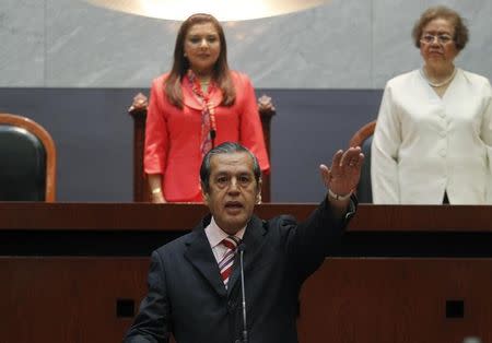 Rogelio Ortega (C), former secretary-general of the Autonomous University of Guerrero, gestures as he becomes the acting governor of Guerrero at the City Congress in Chilpancingo, in the southern Mexican state of Guerrero, October 26, 2014. REUTERS/Jorge Dan Lopez