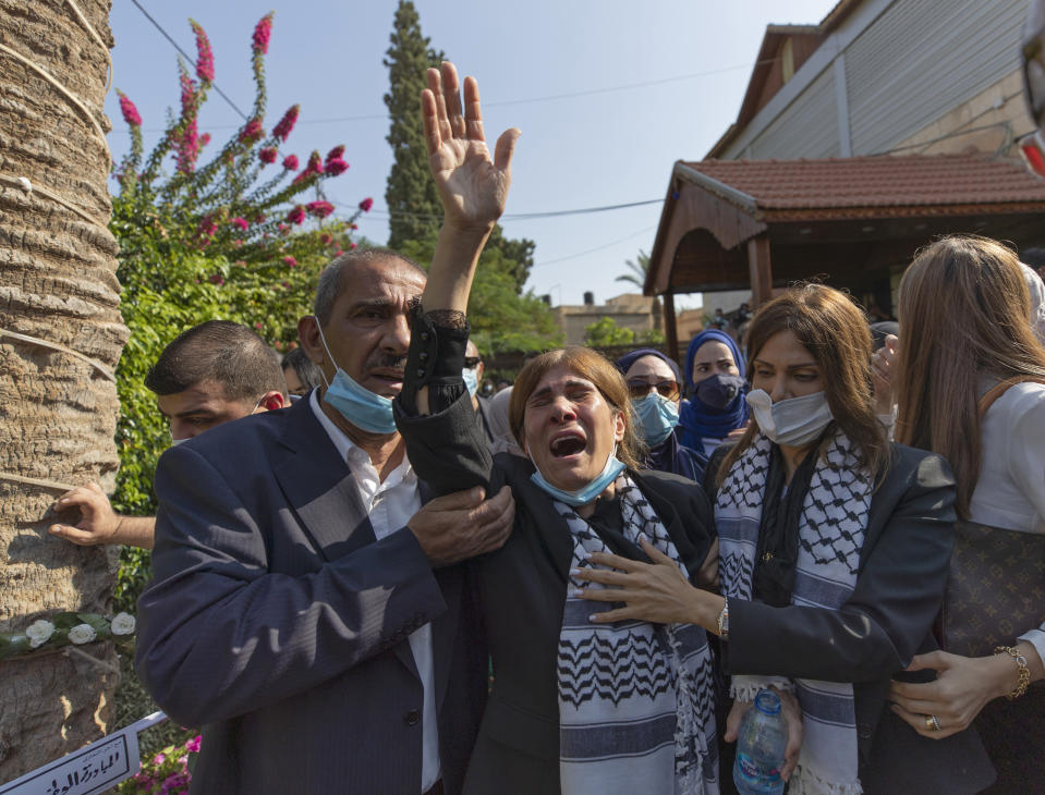 Neameh Erekat, center, reacts during the funeral of her husband Saeb Erekat in the West Bank city of Jericho, Wednesday, Nov. 11, 2020. Erekat, a veteran peace negotiator and prominent international spokesman for the Palestinians for more than three decades, died on Tuesday, weeks after being infected by the coronavirus. He was 65. (AP Photo/Nasser Nasser)
