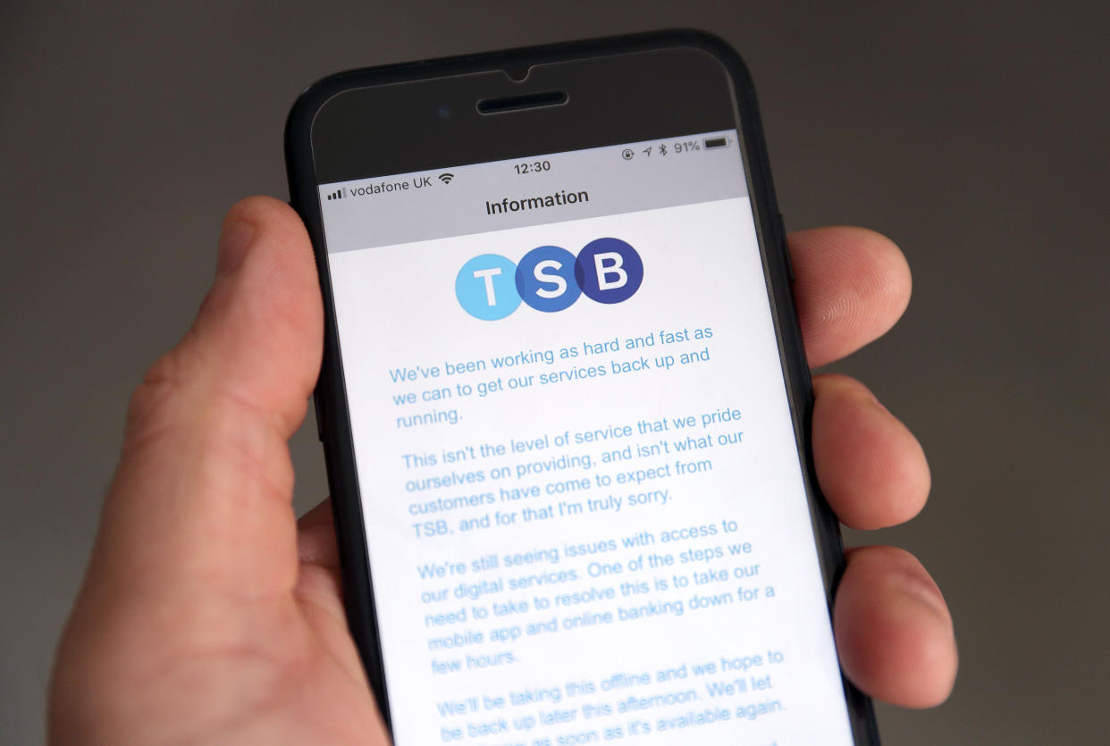 A customer using the TSB Online banking app on an iPhone reads a message from TSB CEO Paul Pester apologising for IT issues which left online customers unable to access their money and some able to see other people's accounts. (Photo by Andrew Matthews/PA Images via Getty Images)