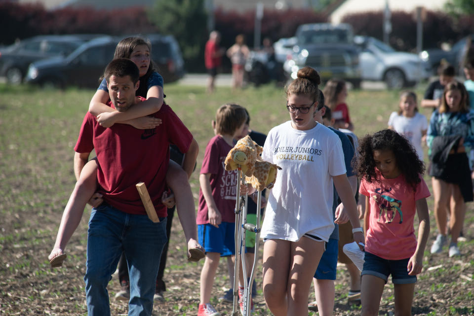 Evacuated students and staff march to buses to be carried offsite outside Noblesville West Middle School.&nbsp;