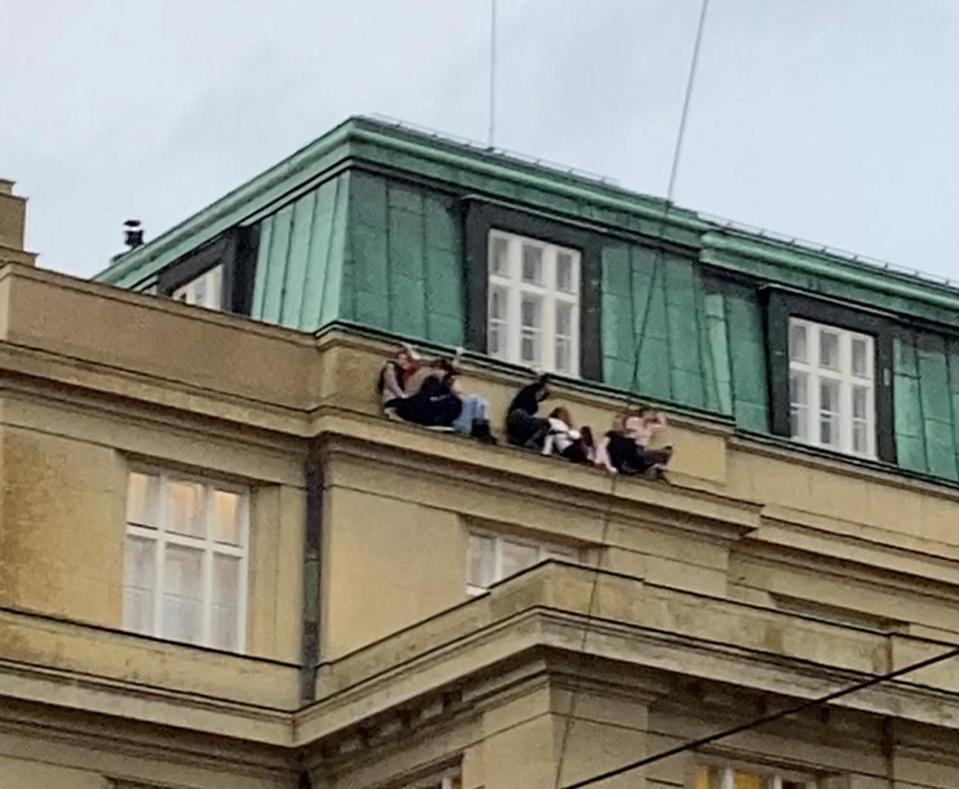 People on a roof following a shooting at one of the buildings of Charles University, in Prague, Czech Republic, December 21, 2023, as seen in this screen grab taken from a social media video. / Credit: Ivo Havranek/via REUTERS