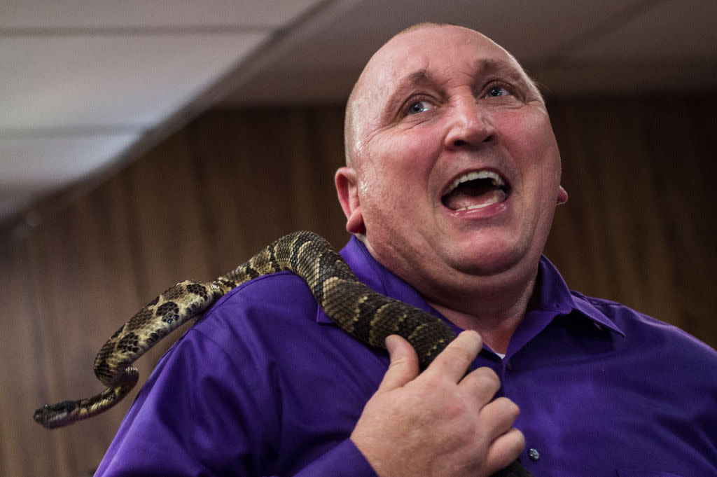 Pastor Chris Wolford sings with a rattlesnake during a Pentecostal service at the House of the Lord Jesus church in Squire, West Virginia, where the faithful speak in tongues. (Credit: Andrew Caballero-Reynolds/AFP via Getty Images)