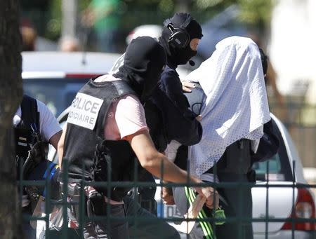 A man supposed to be suspect who held over an attack against a gas company site is escorted by police officers during investigations in Saint-Priest, near Lyon, France, June 28, 2015. REUTERS/Emmanuel Foudrot