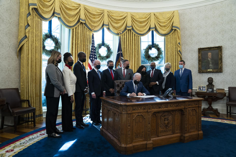 President Joe Biden signs an executive order to improve government services, in the Oval Office of the White House, Monday, Dec. 13, 2021, in Washington. (AP Photo/Evan Vucci)