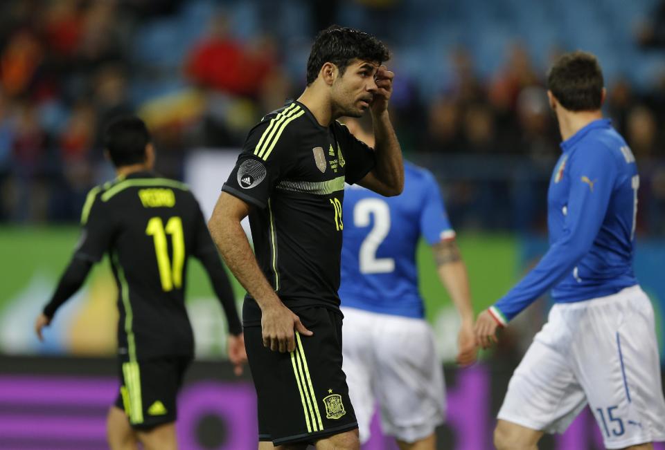 Spain's Diego Costa, centre touches his head during a friendly soccer match against Italy at the Vicente Calderon stadium in Madrid, Wednesday March 5, 2014. (AP Photo/Paul White)