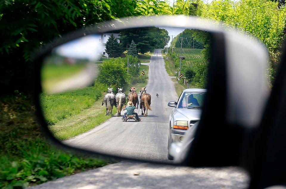 This photo of two Amish teens seen through the side-view mirror of a car from July 12, 2022 is one of Tom E. Puskar's award-winning photo entries in the annual AP contest.